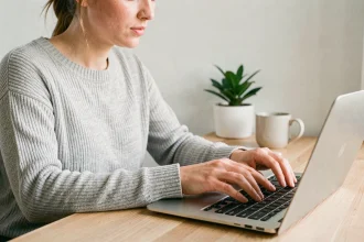 Femme utilisant des raccourcis clavier sur un ordinateur portable dans un bureau à domicile moderne